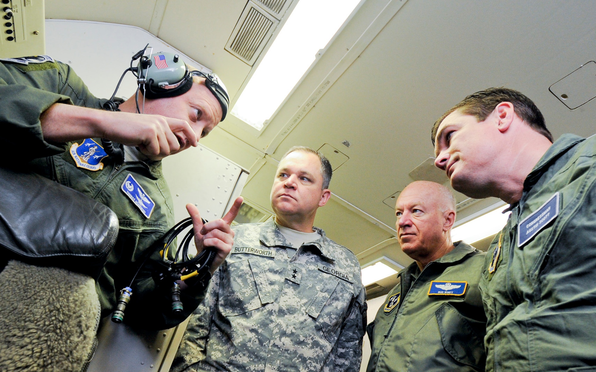 Air National Guard (ANG) Lt. Col. Thomas Grabowski, left, 116th Operations Support Squadron commander, briefs Maj. Gen. Jim Butterworth, Adjutant General of Ga., Lt. Gen. Harry Wyatt III, ANG director, and Congressman Austin Scott, on the mission and capabilities of the E-8 Joint STARS (JSTARS) during an orientation flight aboard the aircraft, Robins Air Force Base, Ga., Dec. 05, 2011.  During the training sortie, JSTARS crew members demonstrated real-world scenarios to show the versatility of the weapon system.  (National Guard photo by Master Sgt. Roger Parsons/Released)
