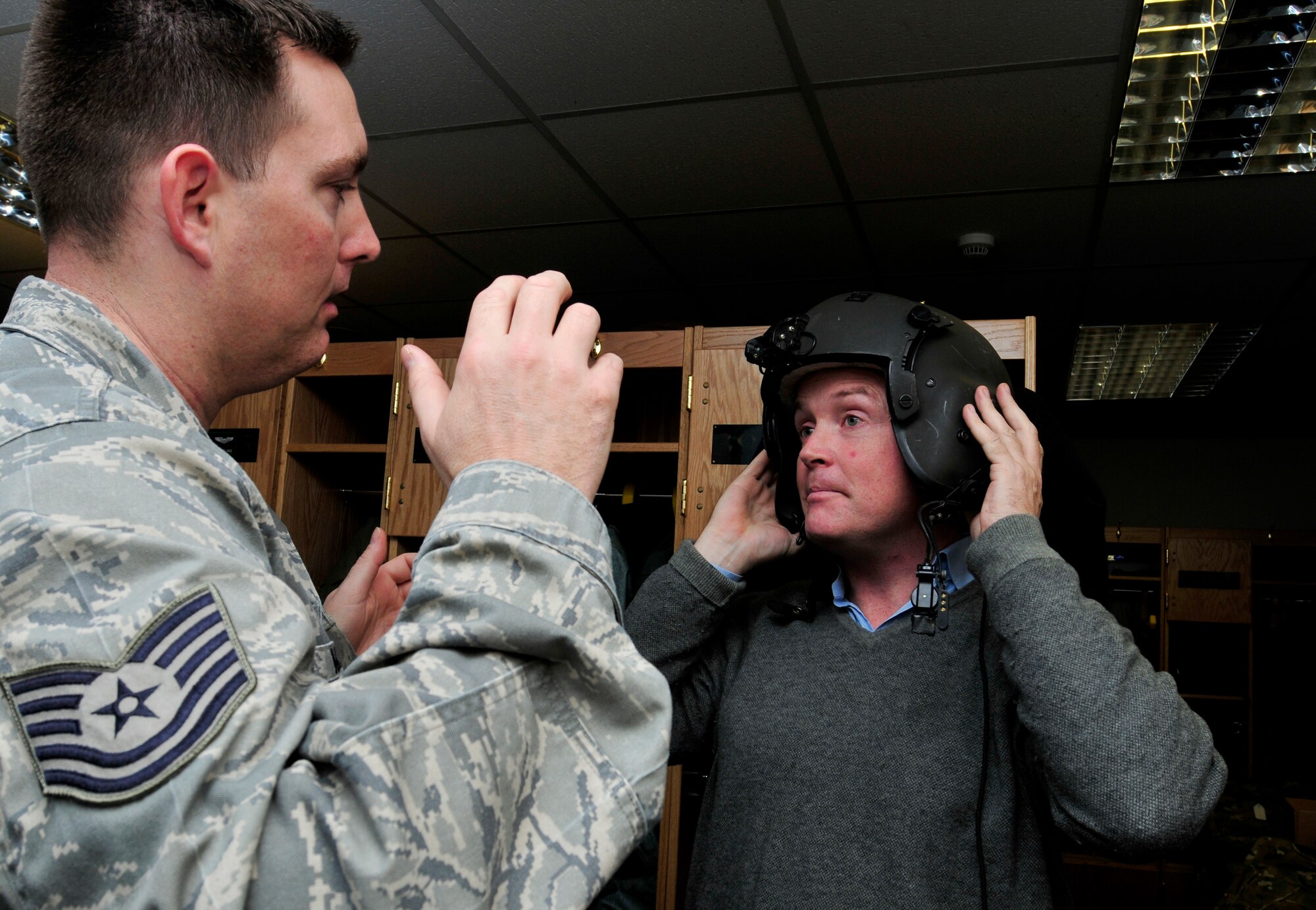 ROYAL AIR FORCE LAKENHEATH, England – Tech. Sgt. Ben Ward, 56th Rescue Squadron Non-commissioned Officer in Charge of Life Support, instructs Lord Edward Iveagh, the Right Honourable Earl of  Iveagh, Deputy Lieutenant and 56th Rescue Squadron honorary commander, on adjusting his helmet in the life support section, Dec. 8, 2011. Iveagh visited the 56th RQS to receive a flight in a HH-60G Pave Hawk and familiarize himself with the 56th RQS mission. (U.S. Air Force photo by Senior Airman Tiffany M. Deuel)