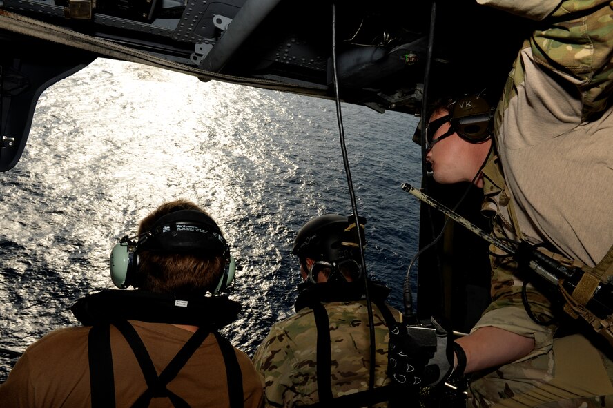 U.S. Air Force Senior Airmen Lee VonHackperestinary and Robert Ziegler along with Staff Sgt. David Schumacher, all pararescuemen from the 31st Rescue Squadron, search from a U.S. Air Force HH-60G Pave Hawk helicopter for simulated victims in the Pacific Ocean during Cope Angel 12 in Okinawa, Japan, Dec. 7 2012. Cope Angel 12 was an exercise from Dec. 5 to 8 that gave pararescuemen from the Japan Air Self Defense Force and U.S. Air Force the opportunity to train together on procedures during a simulated earthquake on the island. (U.S. Air Force photo by Airman 1st Class Maeson L. Elleman/Released)