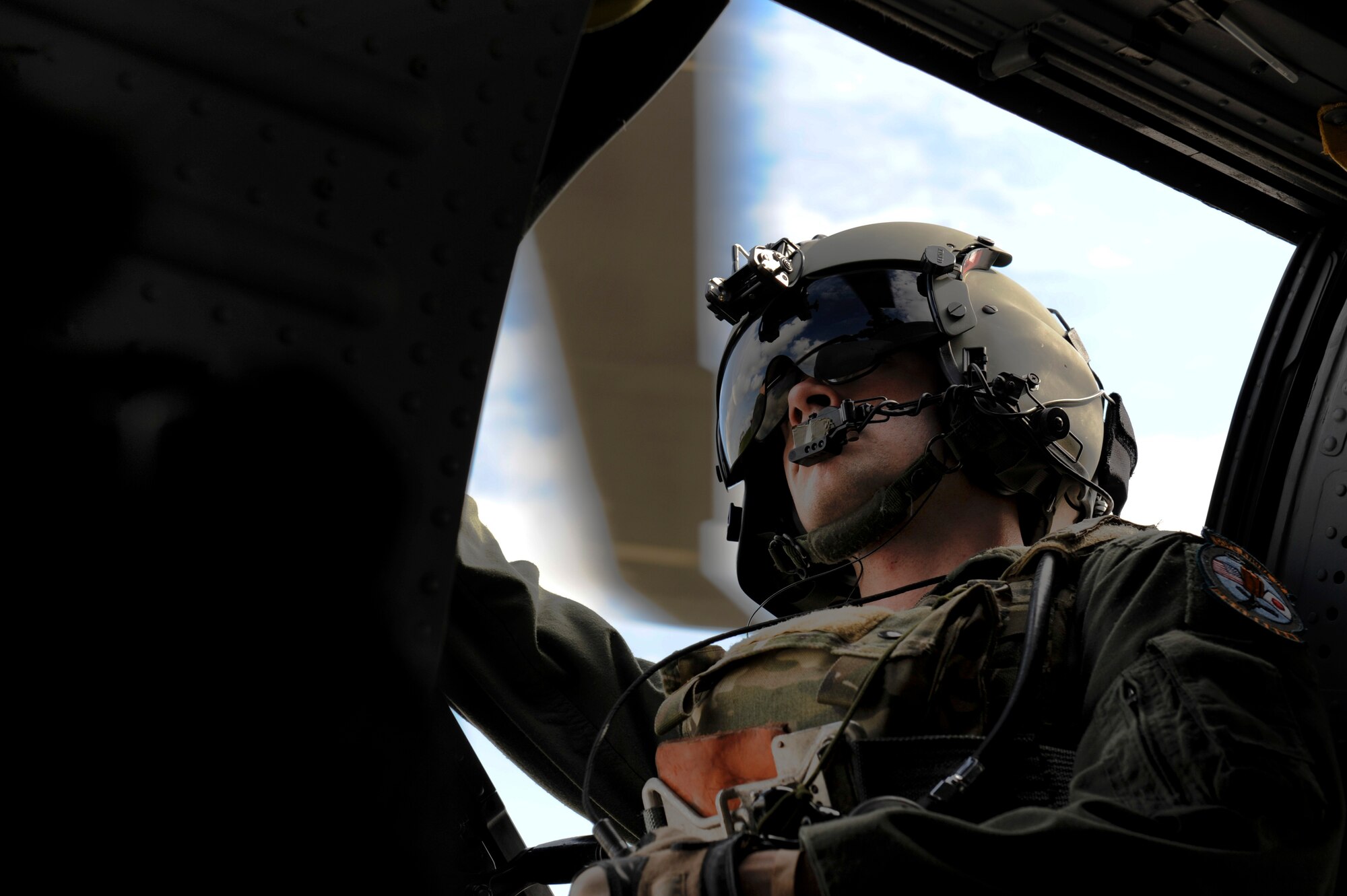 U.S. Air Force Staff Sgt. Thomas Seffernick, 33rd Rescue Squadron gunner, watches the rotors of a U.S. Air Force HH-60G Pave Hawk helicopter for safety as it readies to take off in support of Cope Angel 12 on Kadena Air Base, Japan, Dec. 7, 2012.  During the exercise, 31st and 33rd RQS Airmen partnered up with Japan Air Self Defense Force members in order to train on rescue and triage techniques. (U.S. Air Force photo by Airman 1st Class Maeson L. Elleman/Released)
