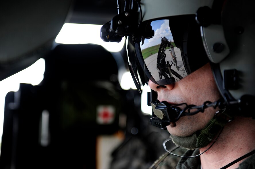 U.S. Air Force Staff Sgt. Thomas Seffernick, 33rd Rescue Squadron gunner, watches a maintainer from the 33rd RQS perform pre-flight checks on the U.S. Air Force HH-60G Pave Hawk helicopter before takeoff on Kadena Air Base, Japan, Dec. 7, 2011. The 33rd and 31st Rescue Squadrons paired up with partners from the Japan Air Self Defense Force during Cope Angel to train on water and land rescue and triage tactics. (U.S. Air Force photo by Airman 1st Class Maeson L. Elleman/Released)