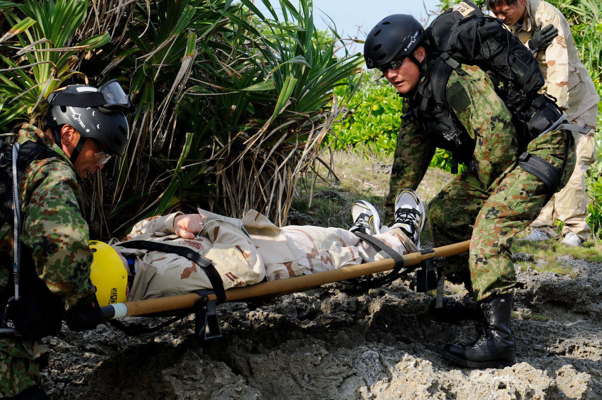 Pararescuemen from the Japan Air Self Defense Force carry a simulated victim in a litter during Cope Angel 12, a bilateral rescue exercise in Okinawa, Japan, Dec. 5, 2011. The 31st and 33rd Rescue Squadrons partnered up with their JASDF counterparts during the exercise to train on essential rescue and triage tactics. (U.S. Air Force photo by Airman 1st Class Maeson L. Elleman/Released)