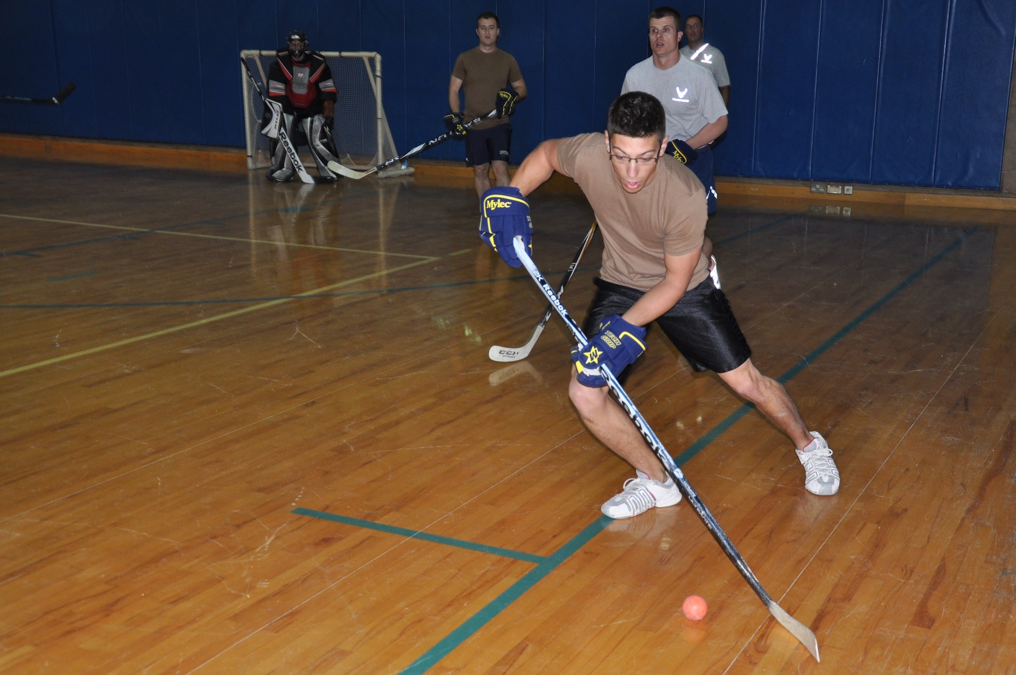 A Royal Canadian Air Force member has control of the ball Dec 2 during the final floor hockey game at an undisclosed location in Southwest Asia. (U.S. Air Force photo by Senior Airman Rachelle Elsea)