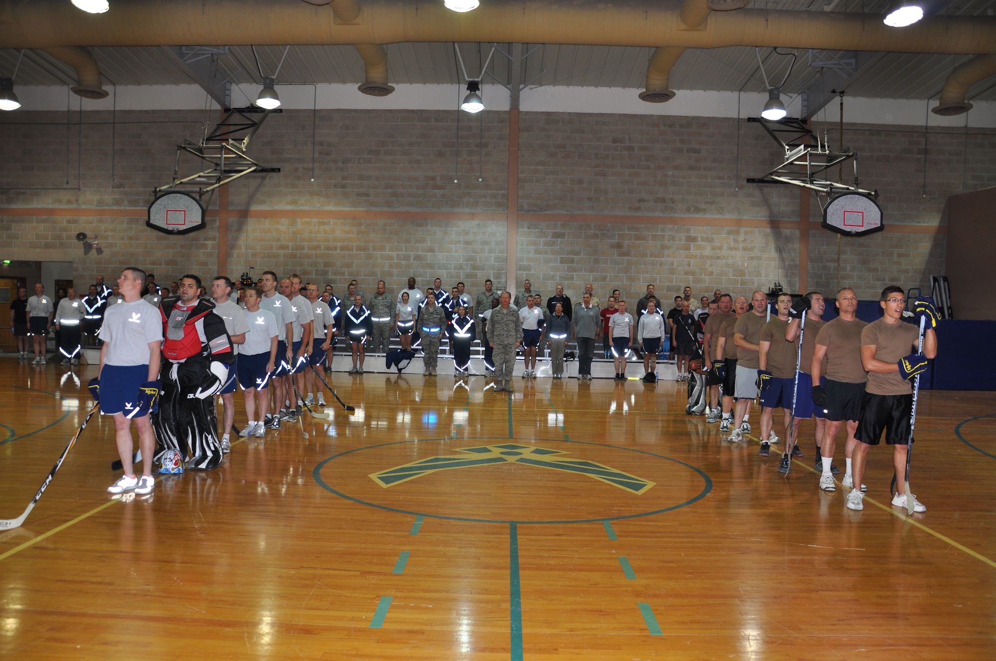 Members of the 386th Air Expeditionary Wing and the Royal Canadian Air Force pay respects to their respected countries with the playing of their National Anthems Dec 2 before the final floor hockey game at an undisclosed location in Southwest Asia. (U.S. Air Force photo by Senior Airman Rachelle Elsea)