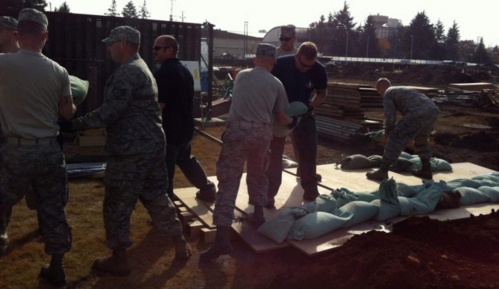 YOKOTA AIR BASE, Japan -- An explosive ordnance disposal team assigned to Commander Fleet Activities Yokosuka, Japan, along with members from the 374th Civil Engineer Squadron place sandbags on a World War II-era unexploded ordnance discovered at Yokota Air Base, Japan, Dec. 7, 2011. Wood, sandbags and sand were placed over the UXO to suppress the blast created during a controlled detonation. (U.S. Air Force photo/Airman 1st Class John D. Partlow)