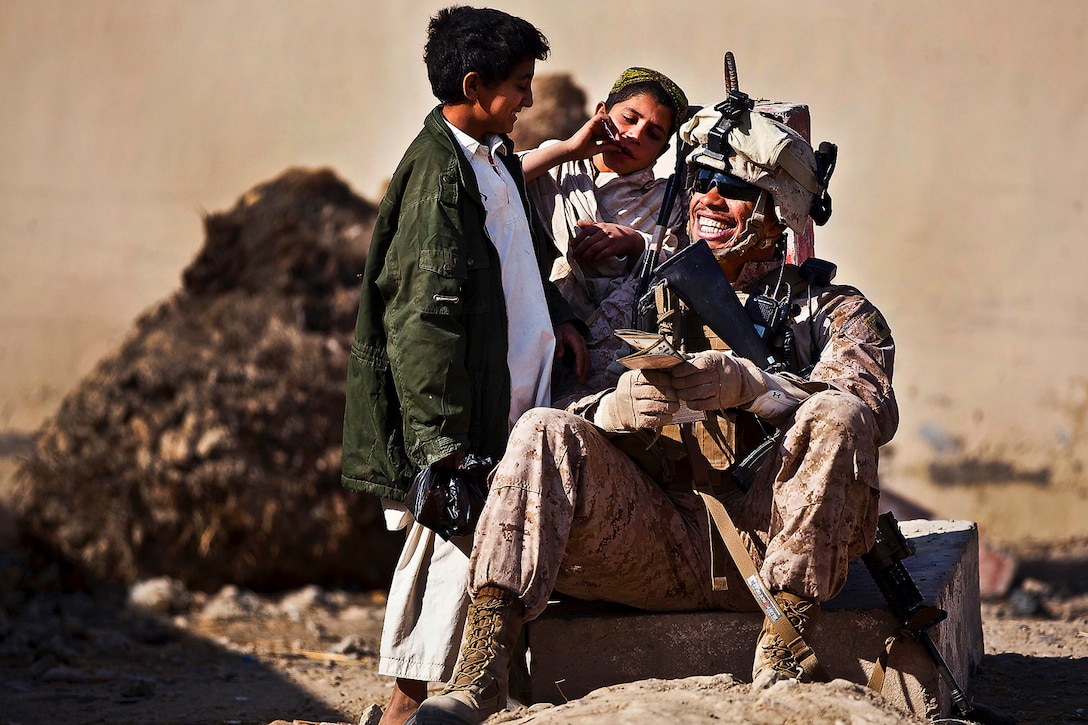 U.S. Marine Sgt. Marcus Martin practices Pashto with Afghan boys while providing security outside the district center in Garmser district, Helmand province, Nov. 28, 2011. Martin is a squad leader assigned to the 3rd Battalion, 3rd Marine Regiment.