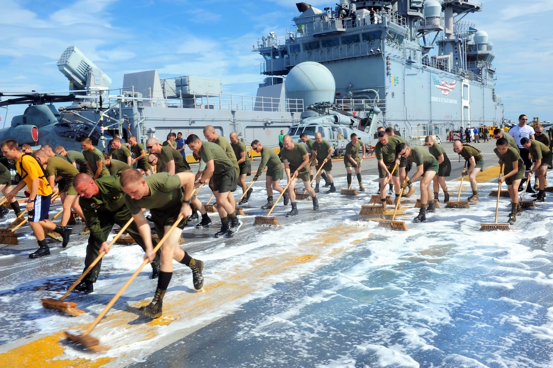 U.S. Navy sailors and Marines scrub down the flight deck of the amphibious assault ship USS Makin Island under way in the Pacific Ocean, Dec. 7, 2011. The Marines are assigned to the 11th Marine Expeditionary Unit. The Makin Island, the Navy's newest amphibious assault ship and the only U.S. Navy ship with a hybrid electric propulsion system, is on its first operational deployment.