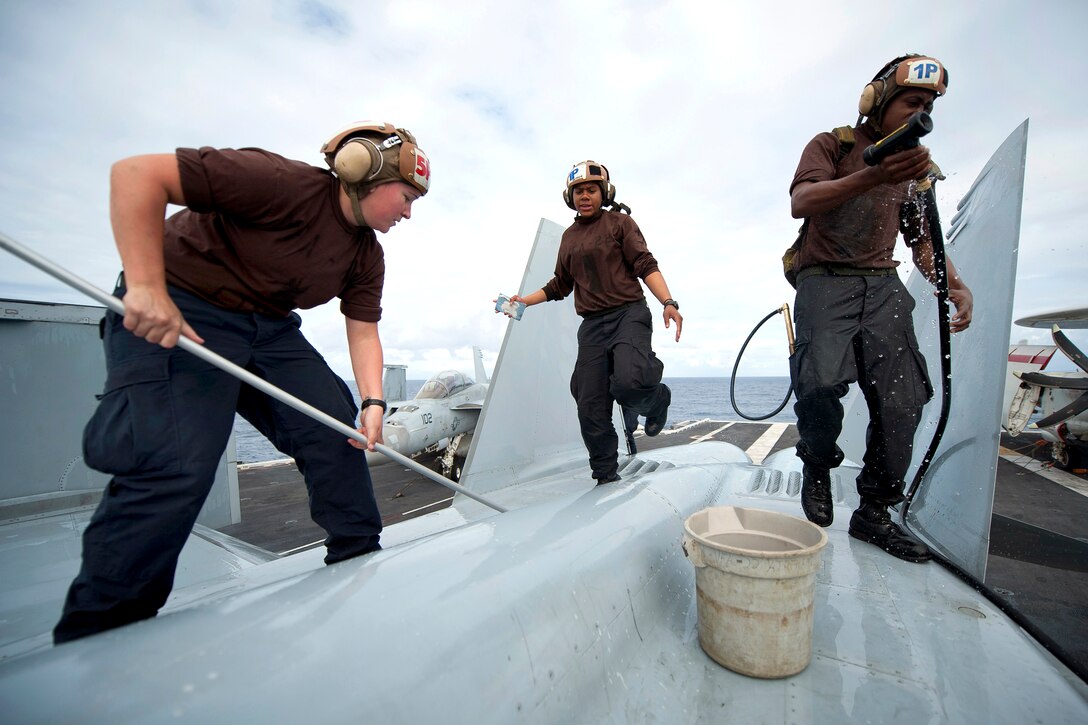 U.S. Navy Seaman Katie Griffith, Petty Officer 3rd Class Veronica Calhoun and Seaman 
Reginald Dean wash down an F/A-18F Super Hornet on the flight deck of the aircraft carrier USS Carl Vinson under way in the Pacific Ocean, Dec. 6, 2011. Griffith is a aviation machinist's mate airman, Calhoun is a aviation electronics technician, and Dean is a aviation structural mechanic airman assigned to Strike Fighter Squadron 22. 