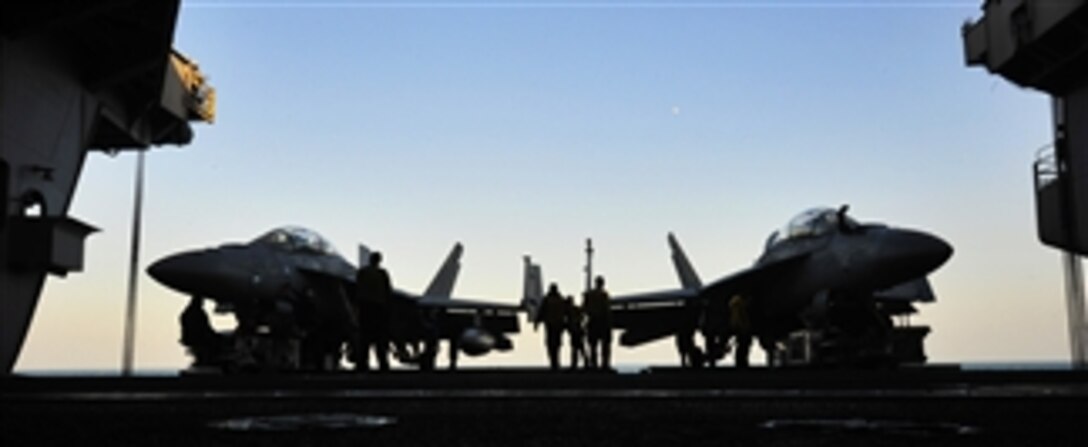 U.S. Navy sailors move fixed wing aircraft aboard the aircraft carrier USS John C. Stennis (CVN 74) in the Persian Gulf on Dec. 6, 2011.  The John C. Stennis is deployed to the U.S. 5th Fleet area of responsibility conducting maritime security operations and support missions as part of operations Enduring Freedom and New Dawn.   