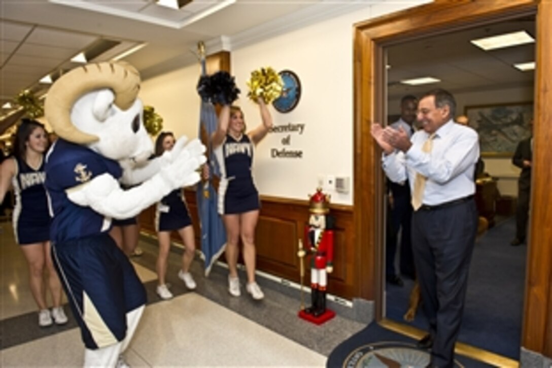 Defense Secretary Leon E. Panetta greets the Navy pep rally  squad outside his office in the Pentagon, Dec. 9, 2011. Each year before the historic game, the Navy and Army pep squads visit the offices of senior Defense Department leaders at the Pentagon. 