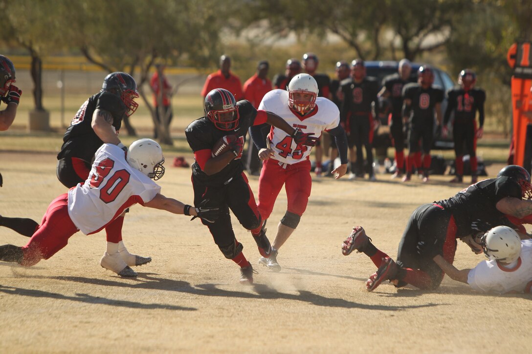 Miramar Falcon half-back Davis Cordero evades the Combat Center Bulldawgs’ defense at the annual Best of the West football game at Felix Field Dec. 7, 2011.