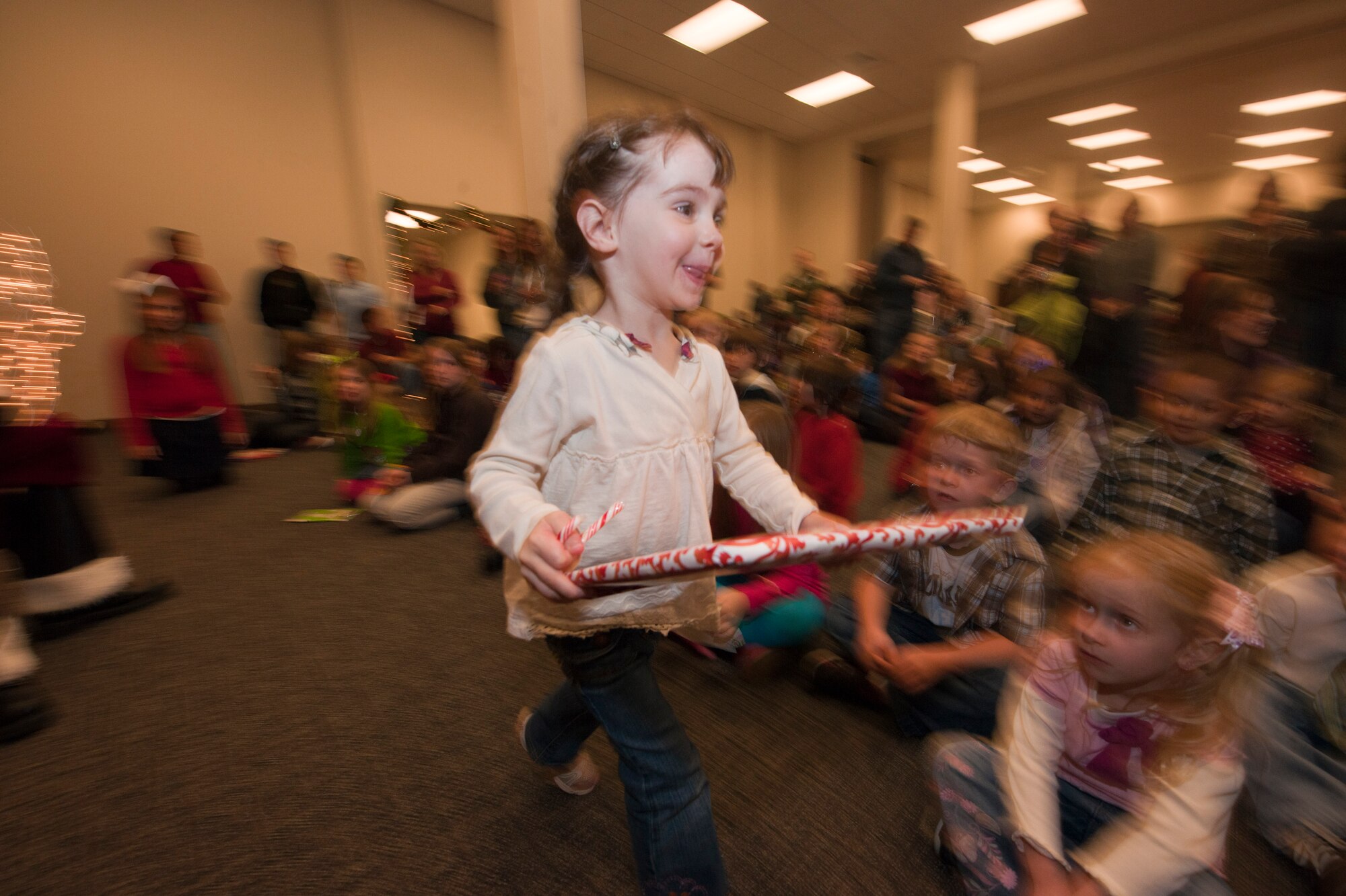 Caitlin Eagan, 2 years old, niece of 1st Lt. Matt Wunderlich from the 345th Airlift Squadron, hurries back to her mommy with a present from Santa Claus. 