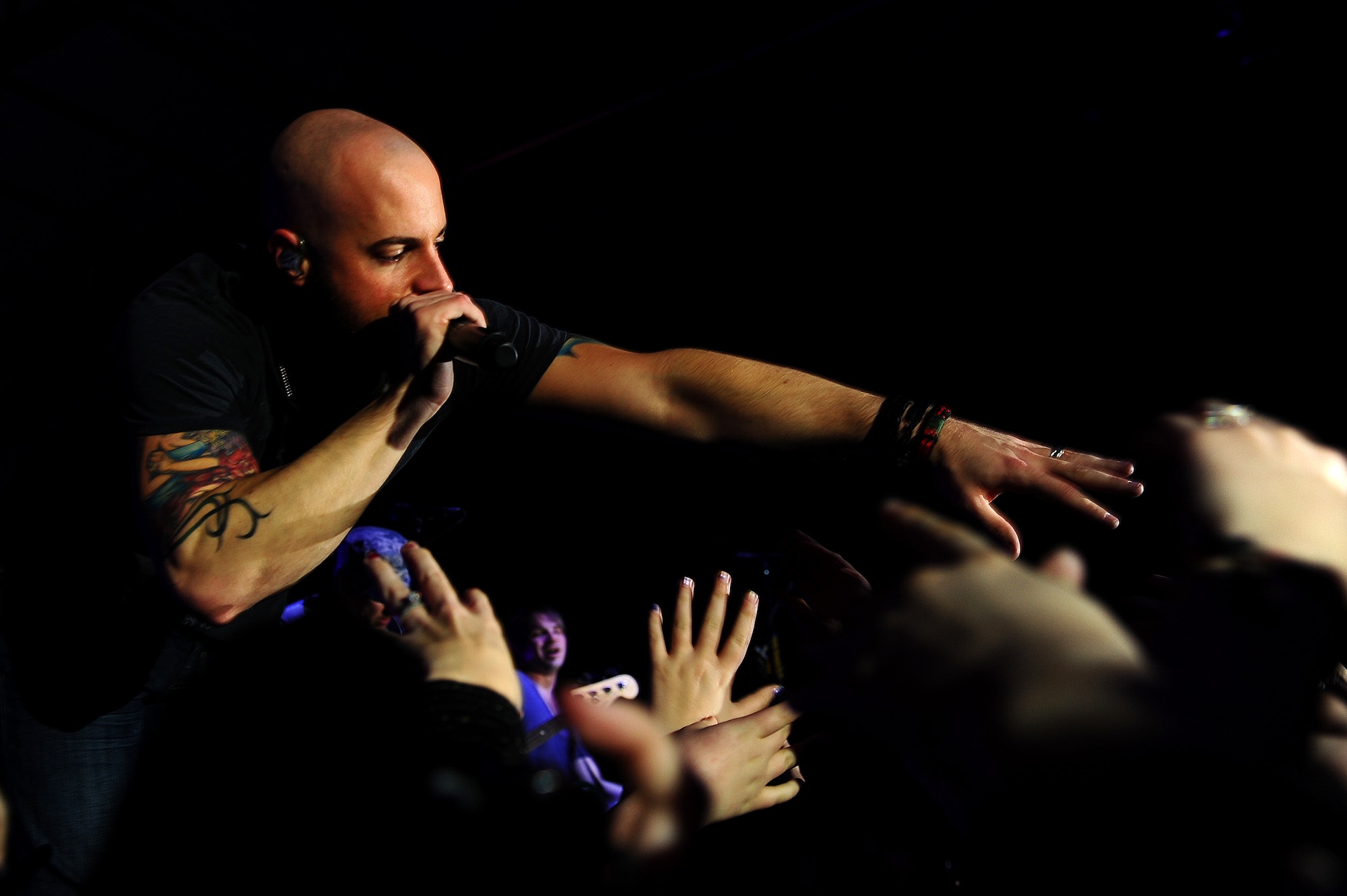 Chris Daughtry, lead singer of the rock band Daughtry, reaches for fans during a concert for service members at Ramstein Air Base, Germany, Dec. 10, 2011. The performers are on a 13-day tour playing six concerts that will take them through Southwest Asia and Europe to bring entertainment to American troops and their families as part of the Operation Seasons Greetings - Tour for the Troops 2011. (U.S. Air Force photo by Airman Brea Miller)