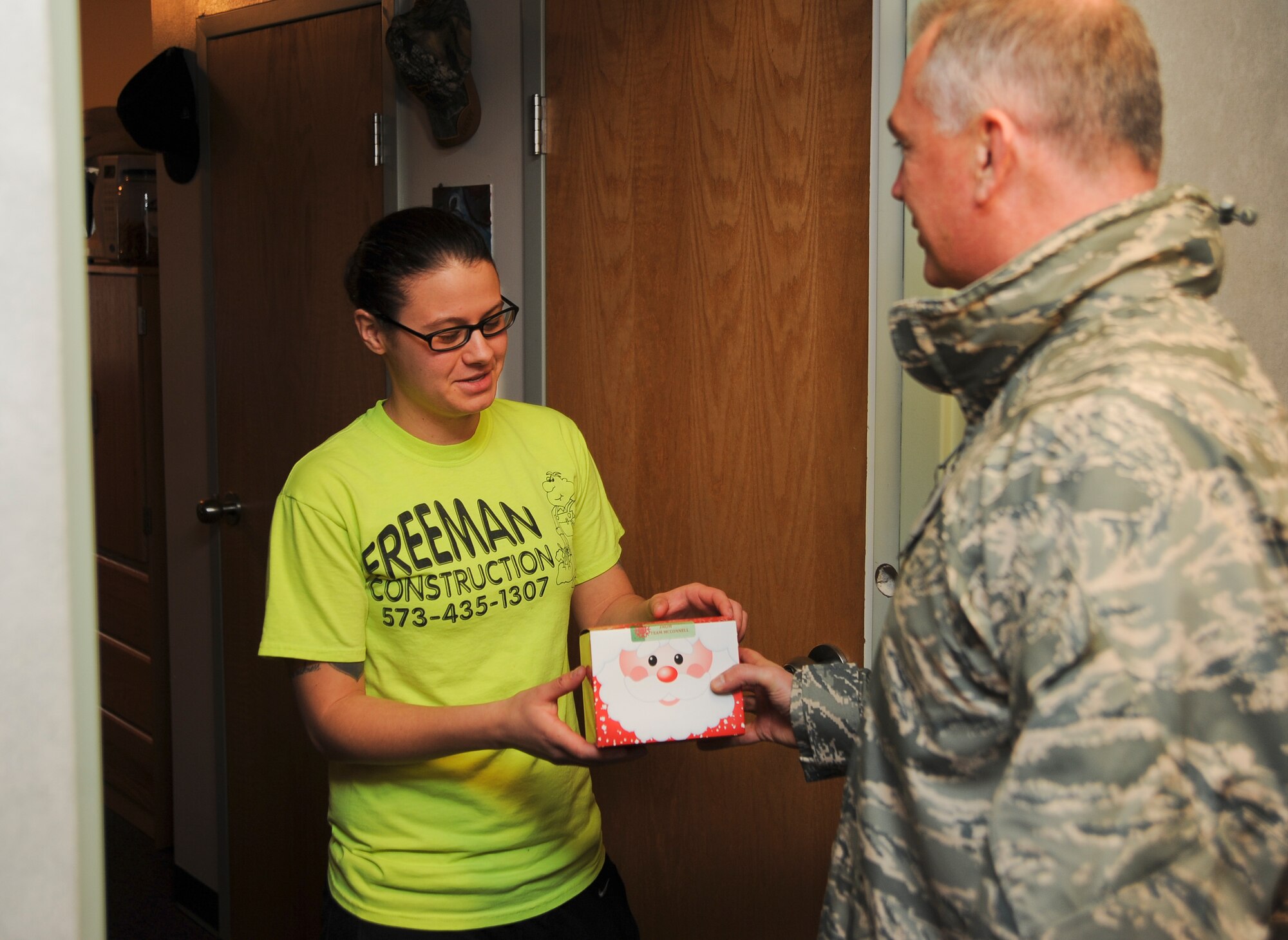 Airman 1st Class Meghan Cox, 22nd Aircraft Maintenance Squadron hydraulics specialist, receives cookies from Col. Ricky Rupp, 22nd Air Refueling Wing commander,  at Dorm 350 Dec. 7, 2011, McConnell Air Force Base, Kan. Volunteers packed more than 400 boxes, delivering them to Airmen in the dormitories.  Base agencies, clubs and local civic leaders donated the cookies and containers. (U.S. Air Force photo/Airman 1st Class Jose L. Leon)