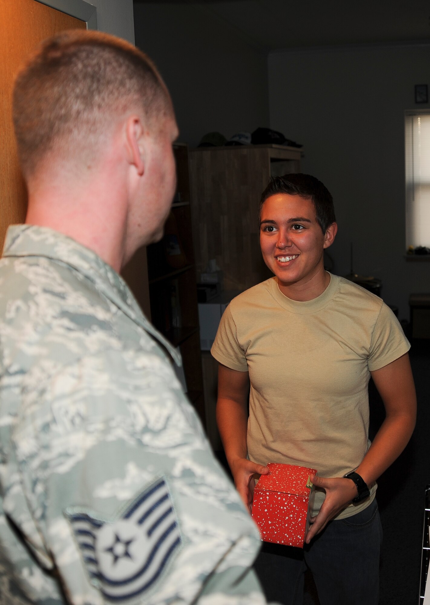 Technical Sgt. Jason Olewnik, 22nd Civil Engineering command support staff member, delivers cookies to Airman 1st Class Cassandra Carvalheira, 22nd Aircraft Maintenance Squadron communications/navigation avionics specialist, at Dorm 350 Dec. 9, 2011, McConnell Air Force Base, Kan. More than 400 boxes of cookies were delivered by volunteers and civic leaders to the Airmen living in all three base dormitories. (U.S. Air Force photo/Airman 1st Class Jose L. Leon)