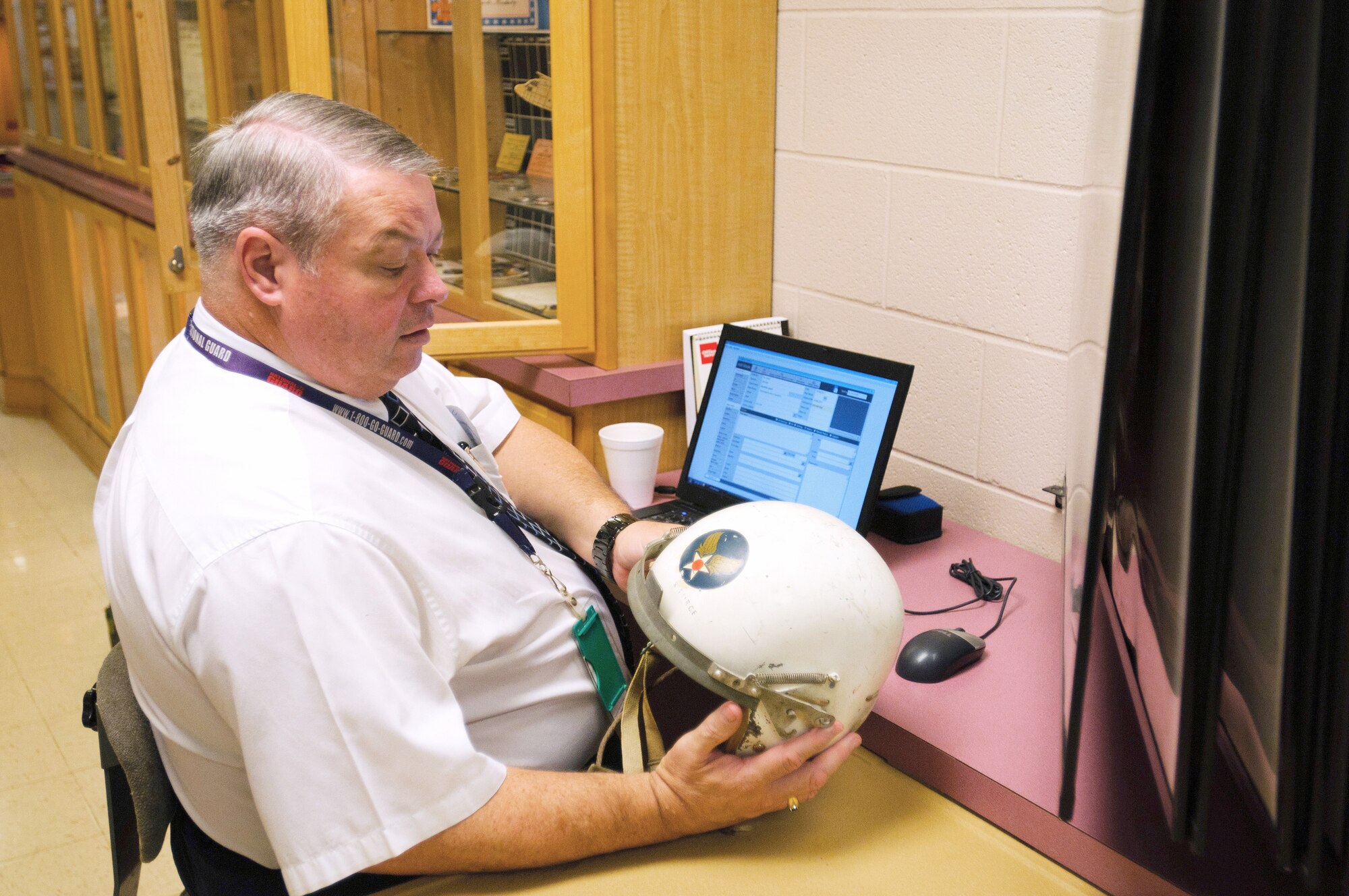 Kentucky National Guard command historian John Trowbridge catalogs a helmet Oct. 6, 2011, during a survey of memorabilia housed in a mini-museum at the Kentucky Air National Guard Base in Louisville, Ky. The museum, called Heritage Hall, lines the hallways of the 123rd Airlift Wing Maintenance Hangar. (U.S. Air Force photo by Master Sgt. Phil Speck)