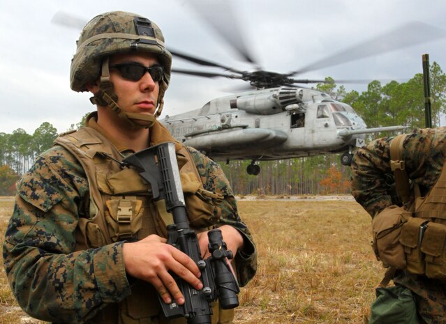 Lance Cpl. Adam Krause, a radio operator with Bravo Company, Battalion Landing Team 1st Battalion, 2nd Marine Regiment, 24th Marine Expeditionary Unit, remains vigilant as a CH-53E Super Stallion lands during a simulated humanitarian assistance operation here Dec. 10, 2011. Supporting humanitarian assistance and disaster relief missions is a task that MEUs train for during their six-month work up period to prepare for deployment. The 24th MEU is currently taking part in Composite Training Unit Exercise (COMPTUEX), scheduled to take place Nov. 28 to Dec. 21. The training is meant to develop cohesion between the 24th MEU and Amphibious Squadron 8 (PHIBRON 8) in conducting amphibious operations, crisis response, and limited contingency operations while operating from the sea.