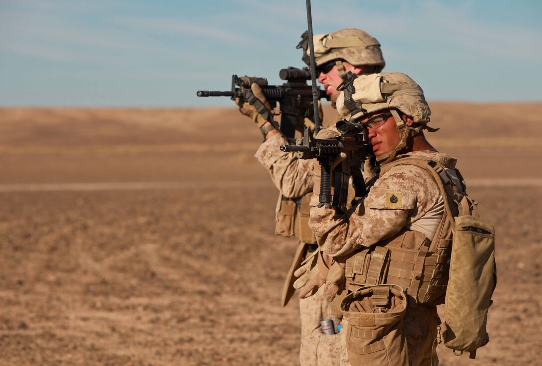 Staff Sgt. Anthony Atkinson (right) looks through his rifle optic during a patrol. The former drill instructor of Long Island, N.Y., was the staff noncommissioned officer for Team 1, Border Advisor Team 1, and agreed his team was able to come together and operate effectively to support Afghan Border Police and Afghan Uniformed Police.
