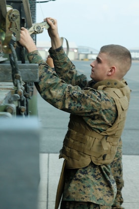 Lance Cpl. Tyler D. Teigen, a Marine Wing Support Squadron 171 combat engineer, releases straps for supplies during flight line and harbor loading and unloading exercises here Monday. This is the first time MWSS-171 has been able to perform an exercise on this scale without actually supporting a unit deployment program squadron.
