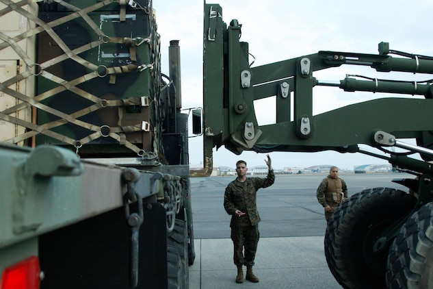 Lance Cpl. Michael A. Futia, a Marine Wing Support Squadron 171 heavy equipment operator, guides a tractor rubber tired articulated steering multipurpose vehicle to lift supplies during flight line and harbor loading and unloading exercises here Monday. The exercises exposed weak points during the squadrons mobilization operations.