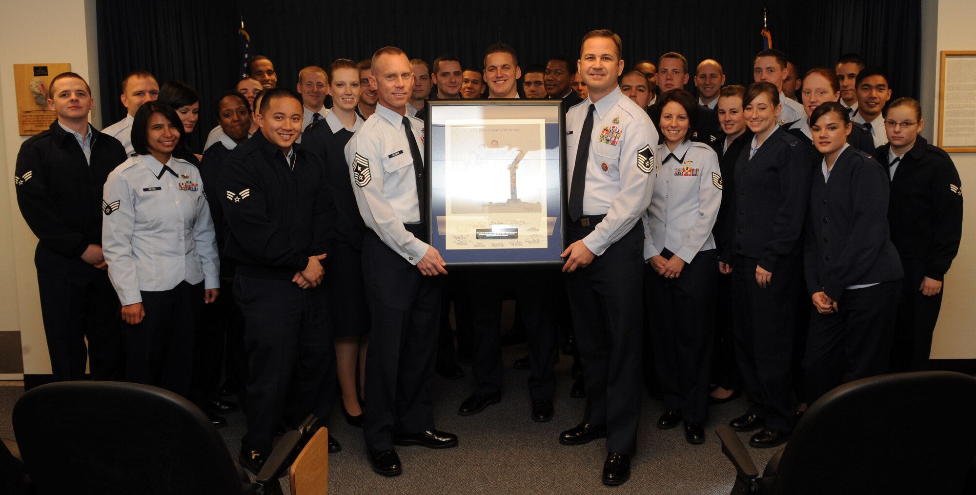 Chief Master Sgt. John Weimer, 366th Fighter Wing command chief, presents a lithograph to Airman Leadership School  students at Mountain Home Air Force Base, Idaho, Dec. 12, 2011. Retired Chief Master Sgt. Mark Reinhardt donated the lithographs which are composed of the surviving chief master sergeants of the Air Force as of 1986 and 1996. (U.S. Air Force photo by Senior Airman Debbie Lockhart)