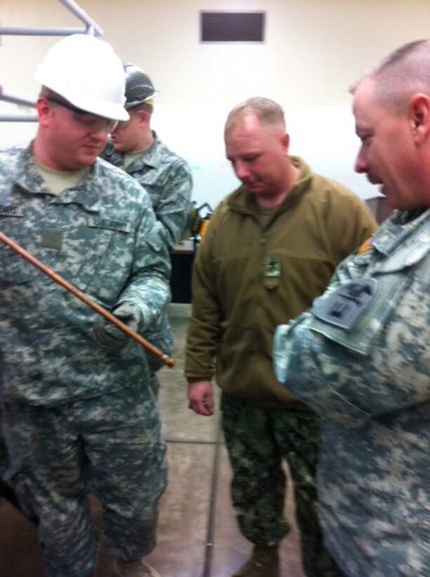 Command Sgt. Maj. William Calhoun, 1st Engineer Brigade command sergeant major (right), tours the 366th Training Squadron Water and Fuels Maintenance Schoolhouse at Sheppard Air Force Base, Texas, Dec. 6, 2011. Col. Allan Webster, 1st EN BDE commander, and Calhoun spent the day observing training and talking to soldiers.