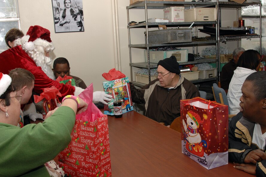 Handicap Are Producers clients receive presents from Santa Claus at the HAP House Christmas party on Barksdale Air Force Base, La., Dec. 9. The clients eagerly awaited the arrival of Santa Claus to pass out gifts for the holiday season. (U.S. Air Force photo/Airman 1st Class Andrew Moua)(RELEASED)
