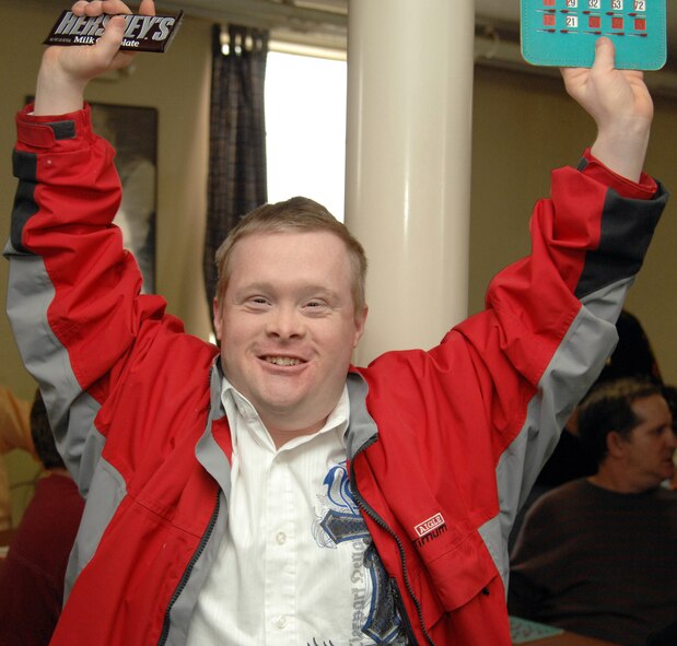 Joshua Holled, client of the Handicap Are Producers House, raises his hands in celebration at the annual HAP House Christmas party on Barksdale Air Force Base, La., Dec. 9. Holled celebrated after winning a chocolate bar during a game of bingo. (U.S. Air Force photo/Airman 1st Class Joseph A. Pagán Jr.)(RELEASED)