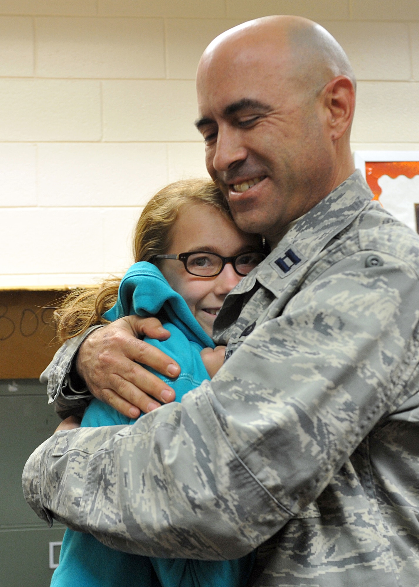 Chloe List gets a long-awaited hug from her father, Capt. Nathan List, during a surprise welcome home at Warner Robins Middle School in Warner Robins, Ga., Dec. 9. List ended his six-month deployment to Al Asad Air Base, Iraq, three weeks early, and with the help of the school staff was able to surprise Chloe in her classroom. List is assigned to the Headquarters Air Force Reserve Command Security Forces Directorate where he is the Chief of Contingency and Readiness Plans. (U.S. Air Force photo/Tommie Horton)