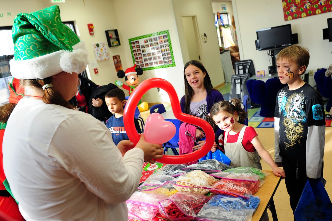 Youth Center staff members create custom designed balloons for military dependant children during Breakfast with Santa at Langley Air Force Base, Va., Dec. 10, 2011. Children also participated in face painting, Christmas stories, arts and crafts, build your own snow, and writing letters to Santa during the event.  (U.S. Air Force photo by Airman 1st Class Kayla Newman/Released)