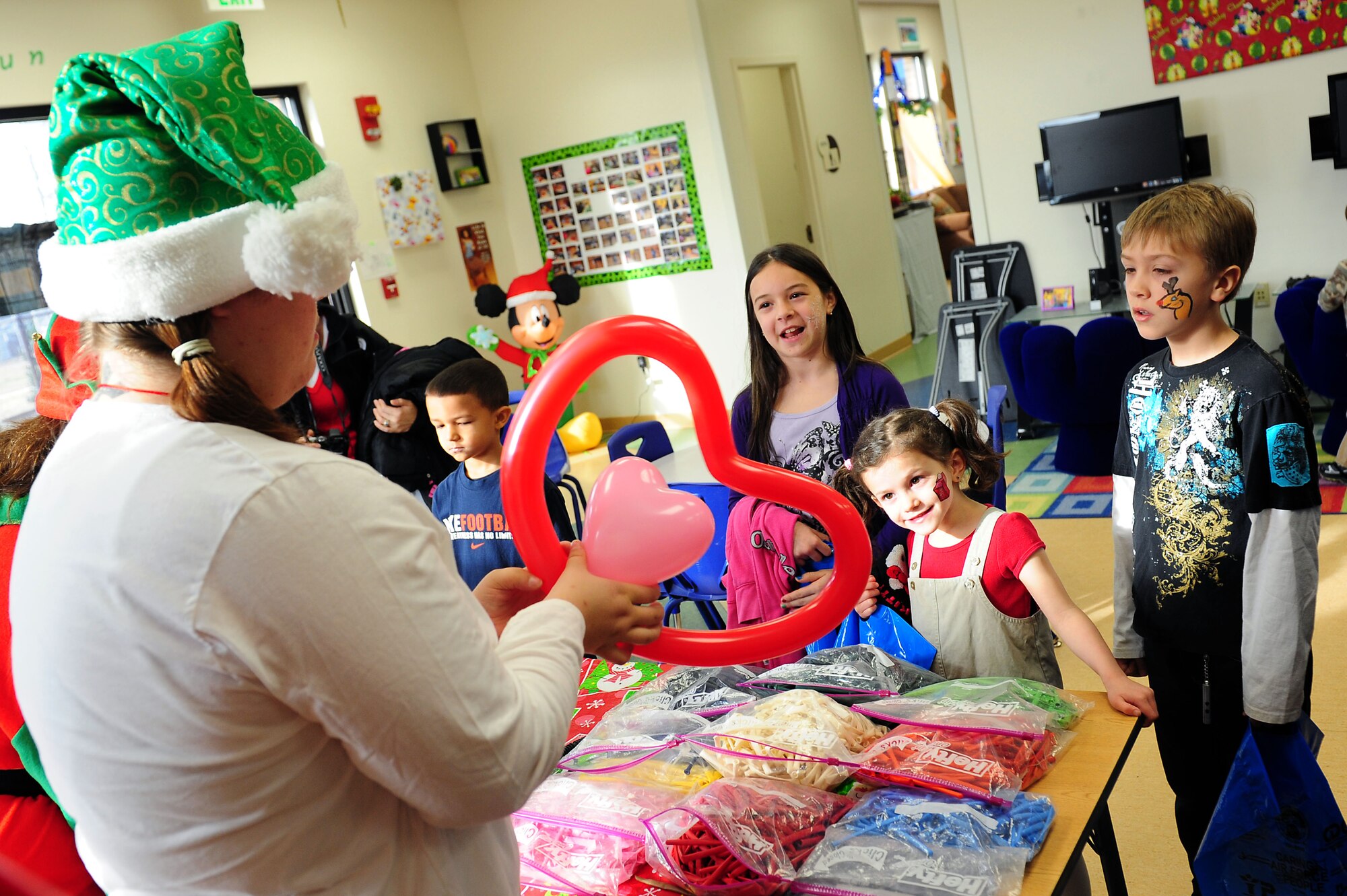 Youth Center staff members create custom designed balloons for military dependant children during Breakfast with Santa at Langley Air Force Base, Va., Dec. 10, 2011. Children also participated in face painting, Christmas stories, arts and crafts, build your own snow, and writing letters to Santa during the event.  (U.S. Air Force photo by Airman 1st Class Kayla Newman/Released)