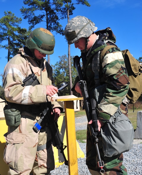 U.S. Air Force Airmen from the 23rd Civil Engineer Squadron post-attack reconnaissance team perform a routine survey of an area in search of contamination during a phase II operational readiness exercise at Moody Air Force Base, Ga., Dec. 8, 2011. The PAR teams checked the prepositioned M-8 chemical agent detection paper for contamination. Contamination checks are just one of many precautions every PAR team performs to ensure quicker return to duty for all Airmen and mission success. (U.S. Air Force photo by Staff Sgt. Stephanie Mancha/Released)
