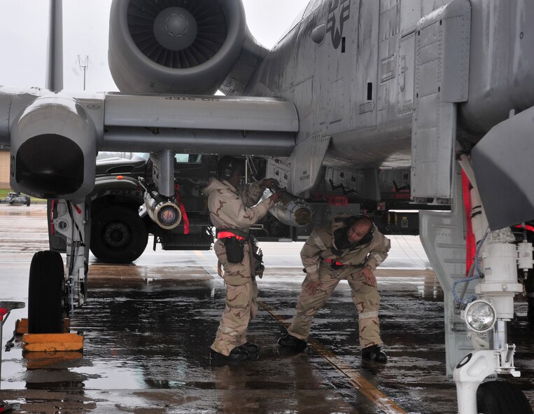 U.S. Air Force weapons armament systems specialists with the 23rd Aircraft Maintenance Squadron secure munitions onto an A-10C Thunderbolt II during a phase II operational readiness exercise at Moody Air Force Base, Ga., Dec. 8, 2011. Following proper procedures and safely working with a sense of urgency increases efficiency in loading munitions onto the aircraft, which is vital to the A-10 mission. (U.S. Air Force photo by Senior Airman Stephanie Mancha/Released)
