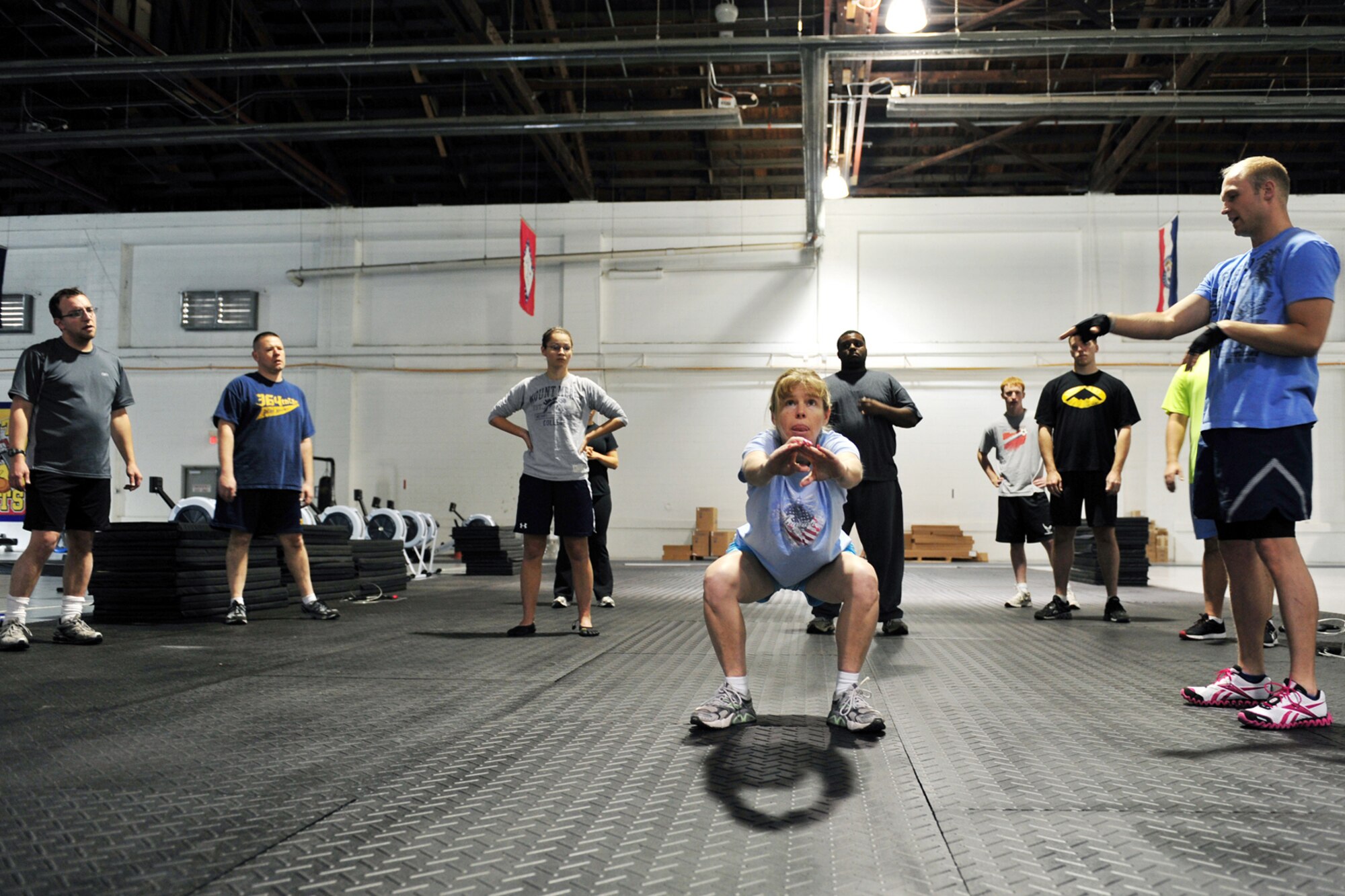U.S. Air Force Senior Master Sgt. Cathy Dugas, 55th Force Support Squadron, demonstrates how to squat properly while U.S. Air Force Staff Sgt. Bryan Holm, 338th Combat Training Squadron, teaches the students during the tactical fitness class in the field house on Offutt Air Force Base, Neb., Nov. 3. The class is being implemented for Team Offutt members after suggestions from field house customers. 

(U.S. Air Force photo by Charles Haymond/Released)