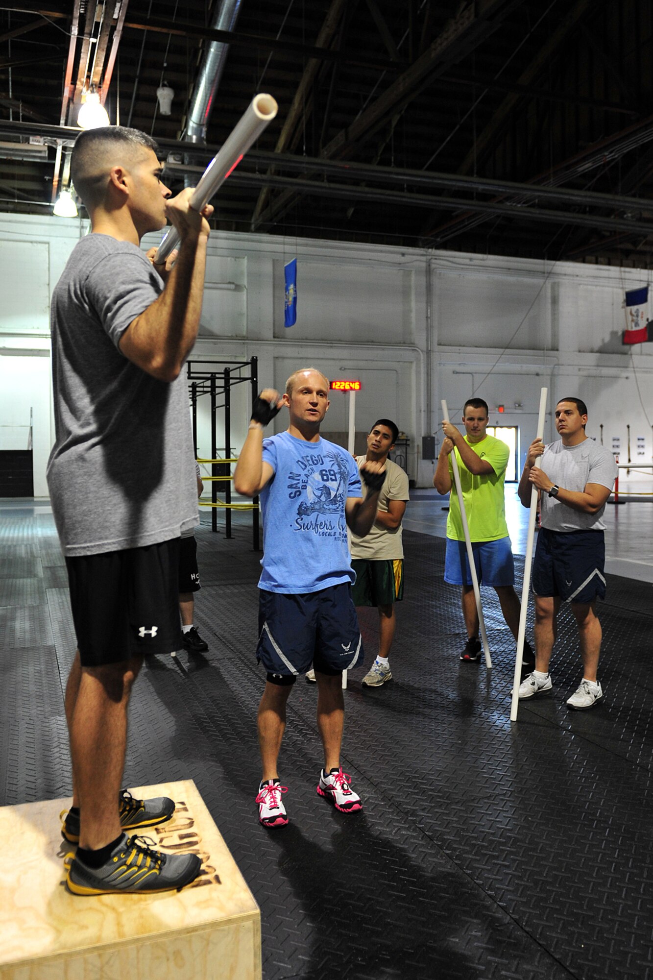 U.S. Marine Maj. Macro Serna, U.S. Strategic Command, holds a piece of polyvinyl chloride pipe while U.S. Air Force Staff Sgt. Bryan Holm, 338th Combat Training Squadron, demonstrates how to do a shoulder press during the tactical fitness class in the field house on Offutt Air Force Base, Neb., Nov. 3. Serna is a CrossFit Level 1 certified instructor. 

(U.S. Air Force photo by Charles Haymond/Released)