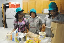 From left, Jaylah Caitlin and Tiars Wilson are guided by youth counselor LaToya Box in preparation for baking goods Tuesday. The Gunter Youth Center made snacks from scratch to deliver to security forces and fire department personnel. This project is one of the several projects the Gunter Youth Center conducts throughout the year. For more information about the Gunter Youth Center, call 416-3436. (Air Force photo/Christopher Kratzer)