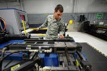 Senior Airman Mark Savoy loads a tube onto an Eaton Leonard Computer Numerical Control production tube bender to fabricate a fuel line for an F-15E Strike Eagle on Seymour Johnson Air Force Base, N.C., Dec. 8, 2011. The tube bender takes inputs from the laser measurement and bends the tube to predetermined measurements. Savoy is an aircraft structural maintenance journeyman with the 4th Equipment Maintenance Squadron and is a native of Riverdale, N.J.  (U.S. Air Force photo by Senior Airman Rae Perry)