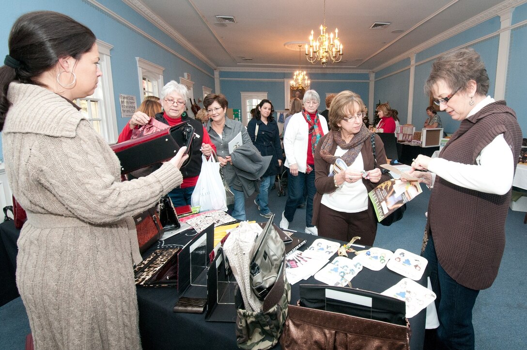 Eager holiday shoppers filled the Maxwell Club Dec. 2 for the Maxwell-Gunter Officers' Spouses Club annual holiday market. Many vendors were on hand to sell a variety of items, including handmade wreaths and bows, as well as cutlery, candles and cookbooks. One of the most popular tables was the baked goods table in the foyer, covered with homemade cookies, fudge and other baked desserts available for the price of a donation. (Air Force photo/Sarah Byrd)