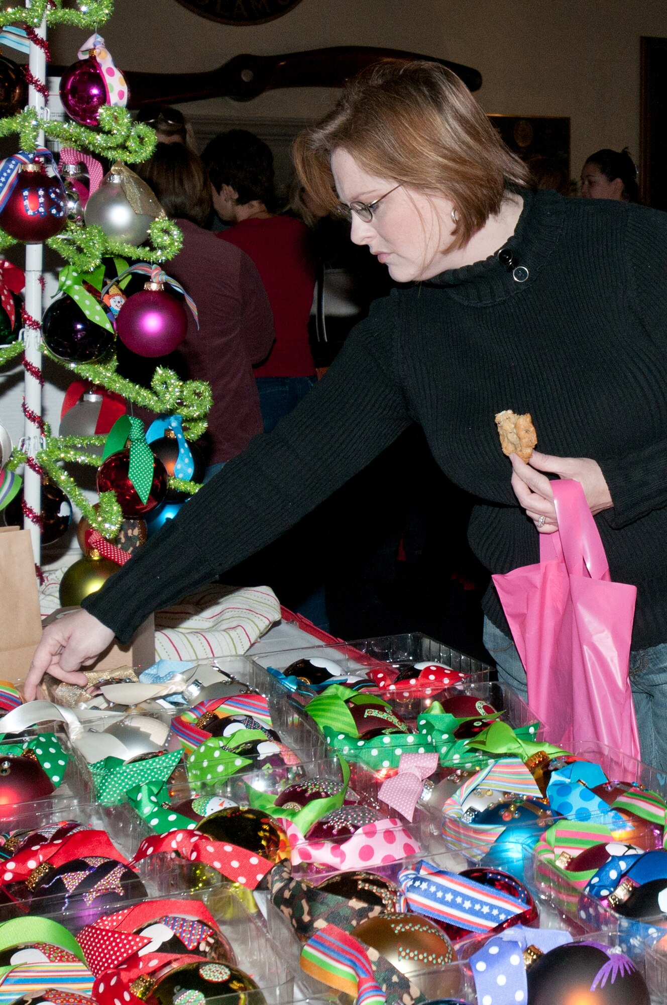 Eager holiday shoppers filled the Maxwell Club Dec. 2 for the Maxwell-Gunter Officers' Spouses Club annual holiday market. Many vendors were on hand to sell a variety of items, including handmade wreaths and bows, as well as cutlery, candles and cookbooks. One of the most popular tables was the baked goods table in the foyer, covered with homemade cookies, fudge and other baked desserts available for the price of a donation. (Air Force photo/Sarah Byrd)