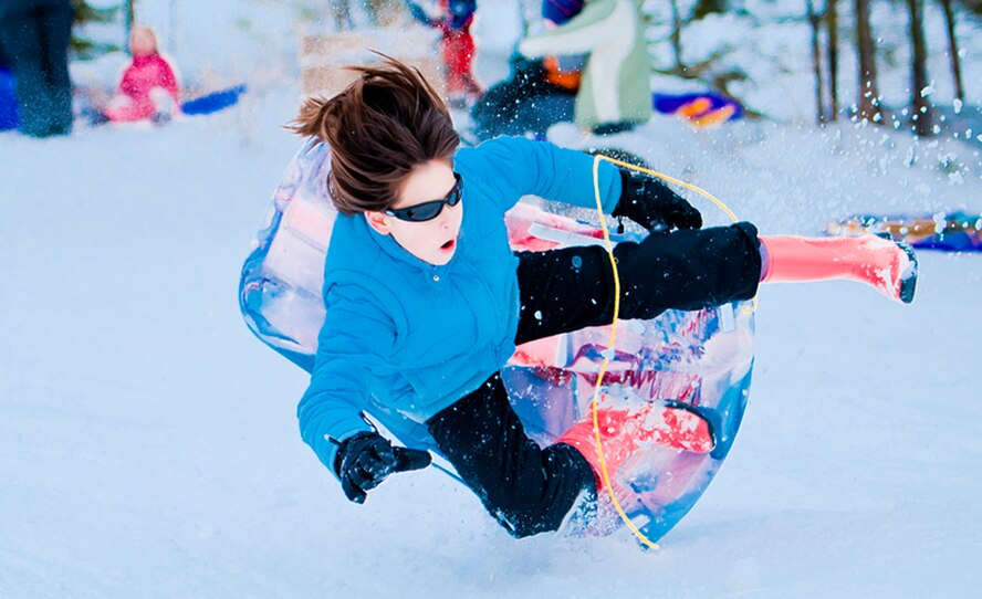 ALTERNATE ENDINGS: Sliding downhill is an exhilarating winter sport. People of all ages can participate, and use all kinds of containers, from large toboggans to plastic disks or even cardboard boxes. But accidental injuries from sledding are surprisingly common despite snow’s cushioning effect. (Photo by Tech. Sgt. Samuel Bendet)