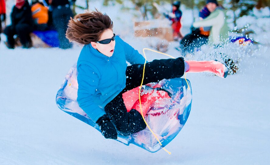 ALTERNATE ENDINGS: Sliding downhill is an exhilarating winter sport. People of all ages can participate, and use all kinds of containers, from large toboggans to plastic disks or even cardboard boxes. But accidental injuries from sledding are surprisingly common despite snow’s cushioning effect. (Photo by Tech. Sgt. Samuel Bendet)