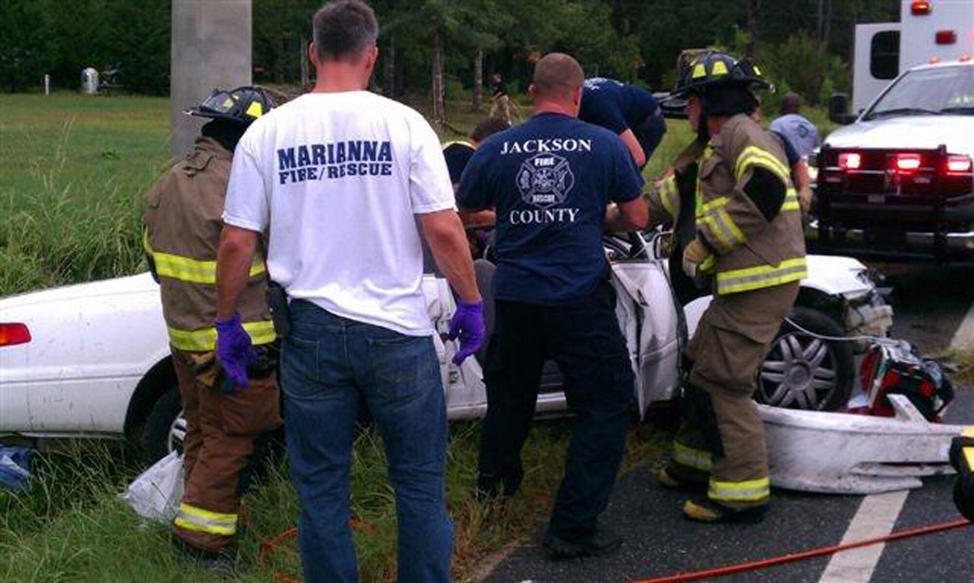 A WRONG TURN WITH GPS: Emergency workers try to save victims of a head-on collision between a car and an ambulance over Labor Day weekend. Three of the four people in the car died, including the driver — an Airman from Naval Air Station, Pensacola, Fla. The driver had been reaching for a cell phone that fell off his lap when he took his eyes off the road, crossed the  center line and hit the ambulance with both vehicles traveling 55 mph. (Courtesy photo)