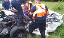 A WRONG TURN WITH GPS: Emergency workers try to save victims of a head-on collision between a car and an ambulance over Labor Day weekend. Three of the four people in the car died, including the driver — an Airman from Naval Air Station, Pensacola, Fla. The driver had been reaching for a cell phone that fell off his lap when he took his eyes off the road, crossed the  center line and hit the ambulance with both vehicles traveling 55 mph. (Courtesy photo)