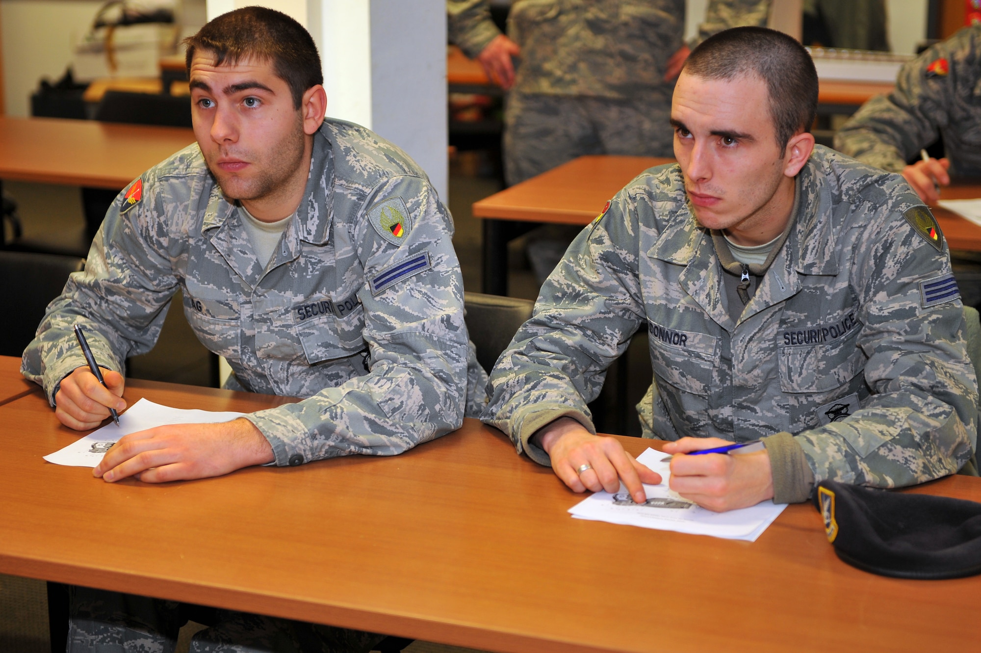 SPANGDAHLEM AIR BASE, Germany – Tobias Krag, left, and Jamen O’Connor, 52nd Security Forces Squadron police officers, complete practice worksheets to memorize the functional parts of a Taser X26 during Taser training inside Bldg. 127 here Dec. 8. Training for the Taser X26 electronic control device consists of a classroom comprehension course, hands-on field training and a supervised firing course. Students complete Taser training to ensure they are able to safely handle and operate all Taser equipment. (U.S. Air Force photo/Airman 1st Class Dillon Davis)