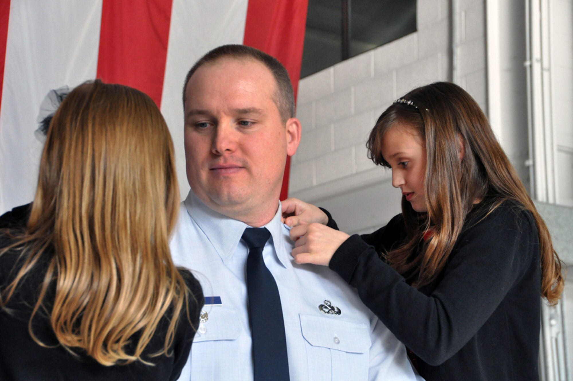 Col. Mark Weber, 305th Maintenance Group deputy commander, takes a knee to allow daughters, Sidney (right) and Avery, during his promotion ceremony to colonel Dec. 2 at Hangar 23 here. (U.S. Air Force photo by 1st Lt. Carolyn Glover/Released) 