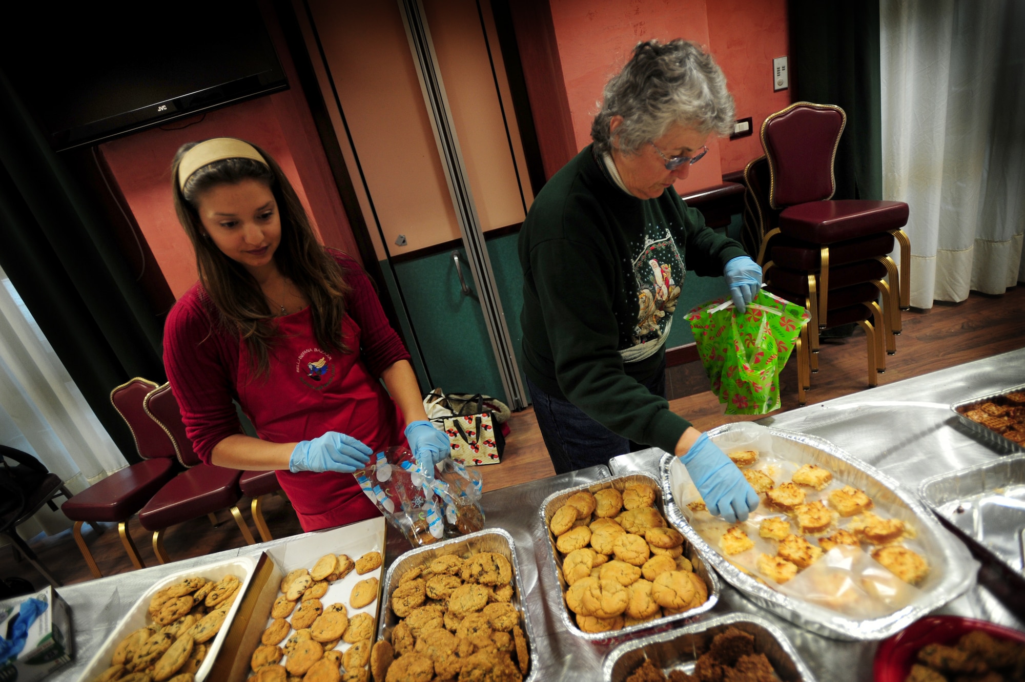(From Left) Alia Riddle and Joyce Kish, volunteers, bag cookies during the 2011 Airmen Cookie Drive Dec. 12 at Aviano Air Base, Italy.  Aviano Officers and Civilian Spouses' Club, and Aviano Community Enlisted Spouses Club as well as other volunteers collected and baked 11,700 cookies for dorm residents and Operation Yellow Ribbon. (U.S. Air Force Photo/Staff Sgt. Evelyn Chavez)