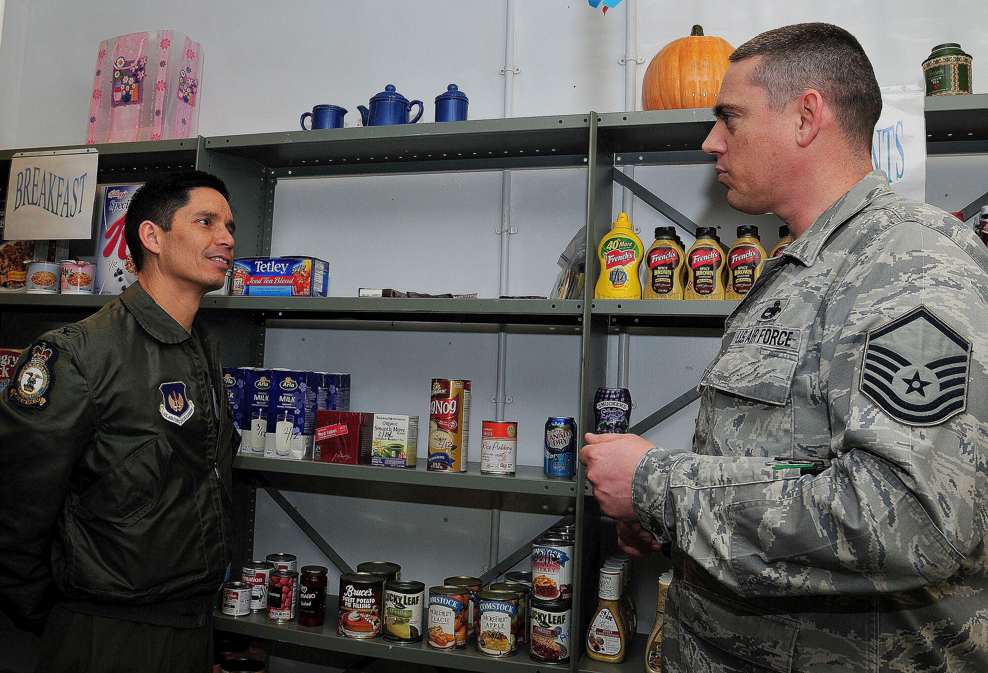 ROYAL AIR FORCE LAKENHEATH, England – Col. John Quintas, 48th Fighter Wing commander, speaks with Master Sgt. Richard Palmer, 48th Component Maintenance Squadron propulsion flight production superintendent, in the food pantry at the RAF Lakenheath Airman’s Attic, Dec. 9, 2011. Quintas donated $5,000 to the attic for building upgrades to include new carpet and shelves. (U.S. Air Force photo by Senior Airman Tiffany M. Deuel)