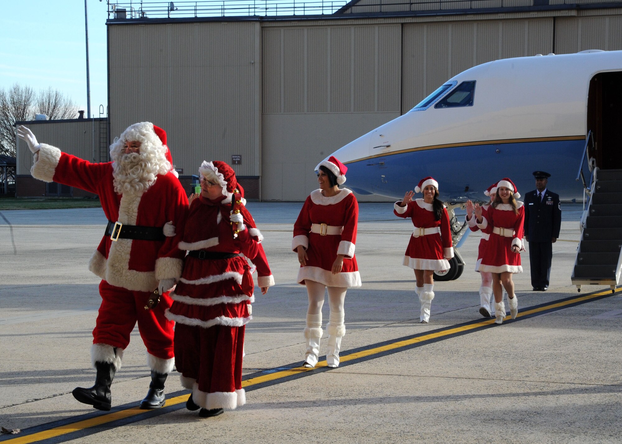 Mr. and Mrs. Santa Clause arrive in style to the Parents and Children Fighting Cancer holiday event in a C-37A aircraft. The Claus’ were a special guest at the holiday event Dec. 3 where they distributed gifts to families. (U.S. Air Force photo/Senior Airman Bahja J. Jones)