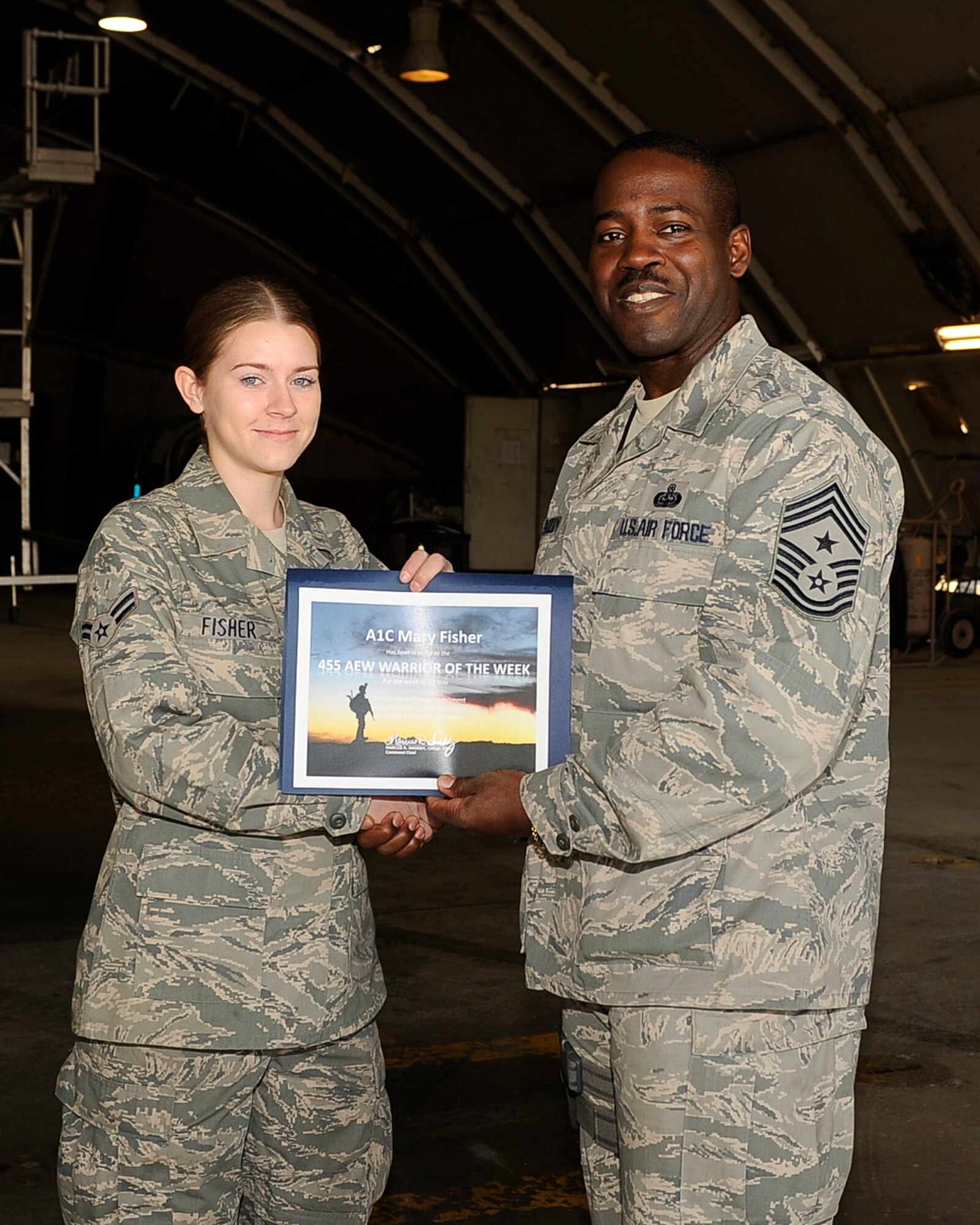 BAGRAM AIRFIELD, Afghanistan - Chief Master Sgt. Marcus Snoddy, 455th Air
Expeditionary Wing command chief, congratulates the Warrior of the Week,
Airman 1st Class Mary Fisher, 455th Expeditionary Maintenance Squadron F-15E
Strike Eagle phase journeyman, for her hard work and dedication Dec. 12,
2011. Fisher is deployed from Seymour Johnson Air Force Base, N.C., and is a
native of Rensselaer, Ind. (U.S. Air Force photo/ Senior Airman Krista Rose)

