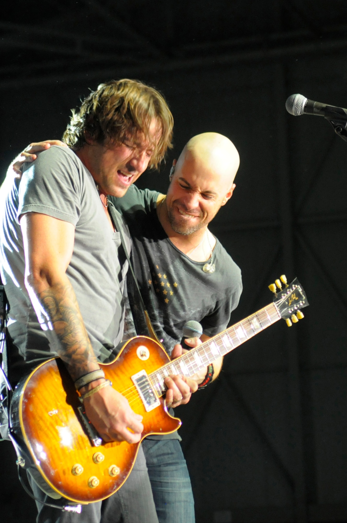 Chris Daughtry jams with his guitarist, Josh Steely, during a concert at Hangar 1 in Ramstein Air Base, Germany, Dec. 10, 2011. The rock band Daughtry, comedian Gabriel "Fluffy" Iglesias and the Band of the U.S. Air Force Reserve performed during a concert for more than 4,000 service members. The performers finished out their 13-day tour at Ramstein. Their six concerts took them through Southwest Asia and Europe to bring entertainment to American troops and their families as part of the Operation Seasons Greetings - Tour for the Troops 2011. (U.S. Air Force photo by Staff Sgt. Travis Edwards)